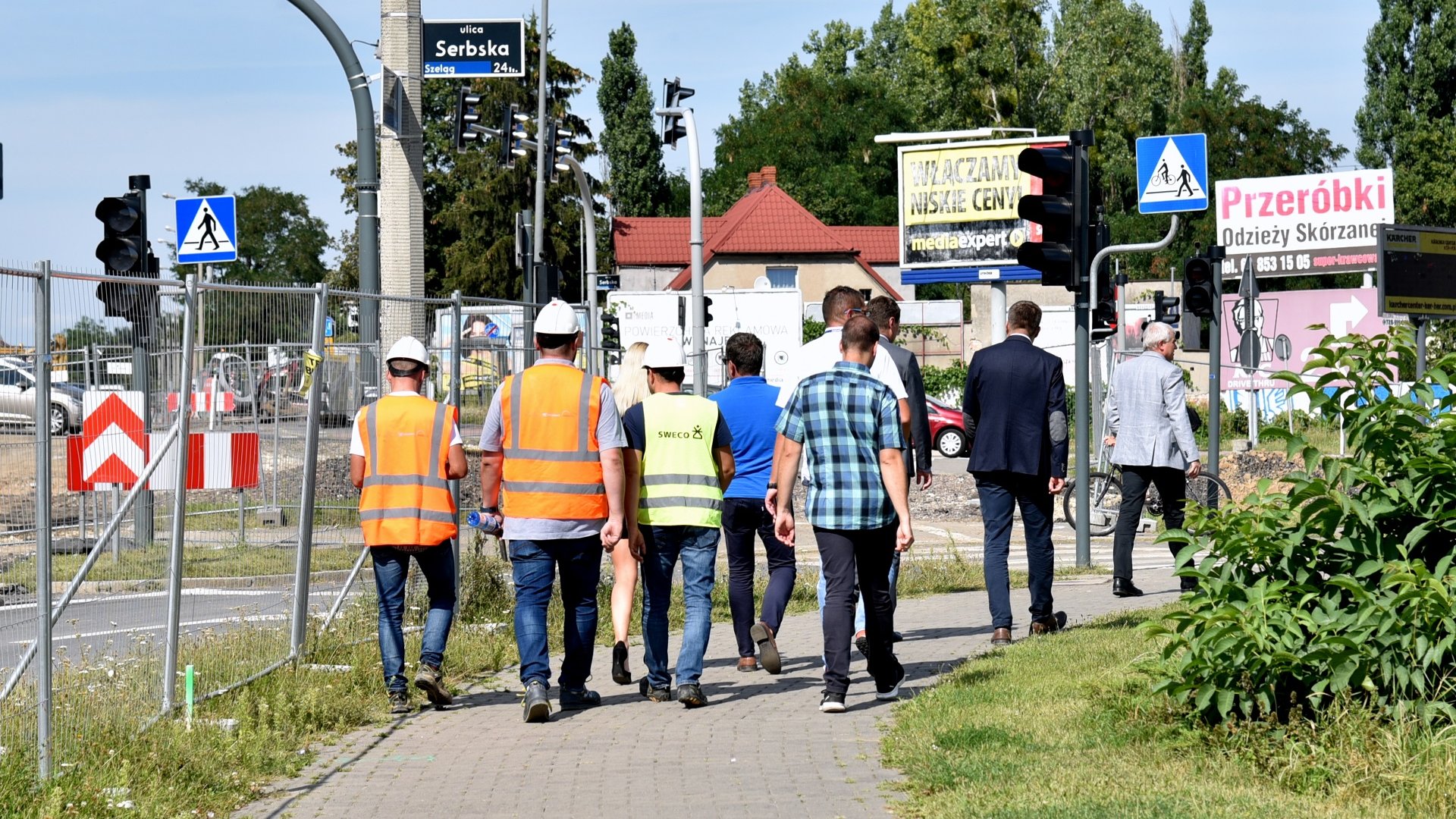 Na zdjęciu znajdują się idący chodnikiem przedstawiciele urzędu miasta, ZDM, PIM oraz wykonawcy prac