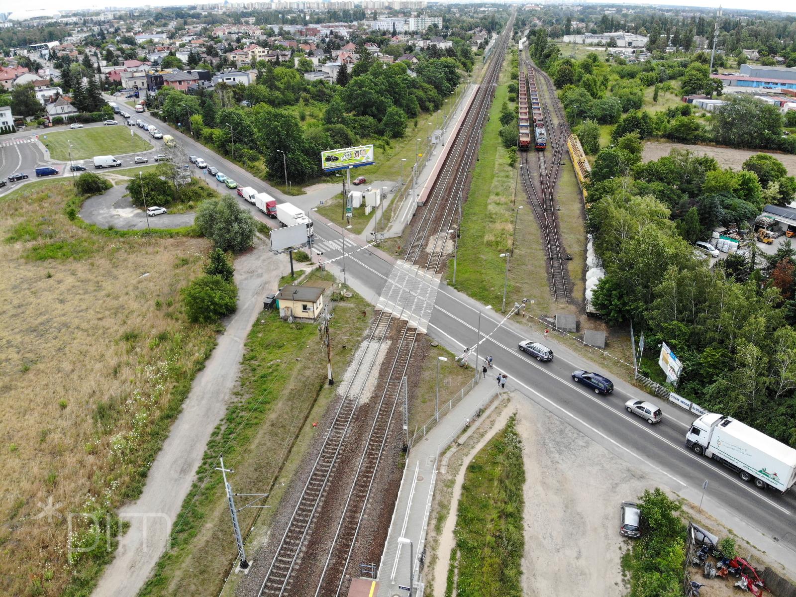 Widok z góry na drogę przecinającą tory kolejowe. - grafika artykułu