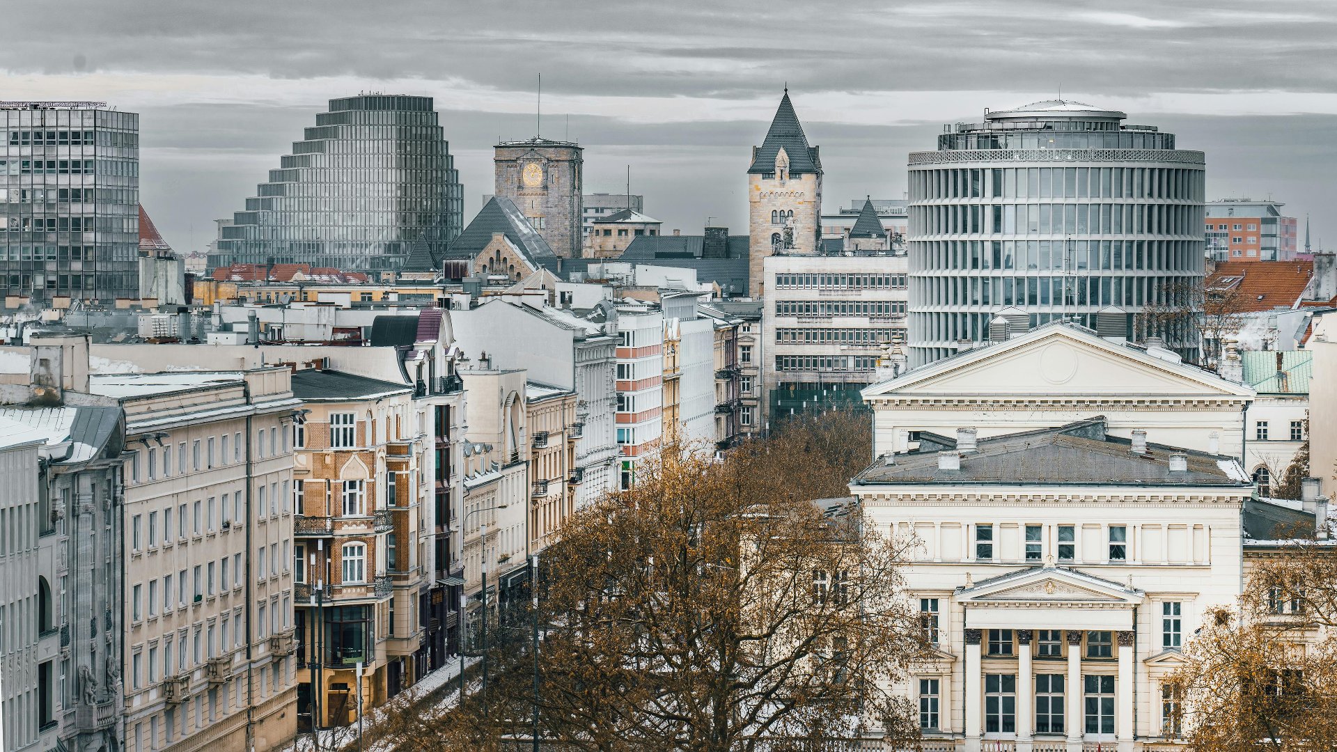 Na zdjęciu widać fragment centrum Poznania. Po prawej stronie widać fasadę Arkadii od strony placu Wolności, a za nią Okrąglak. Po lewej stronie widać ciąg kamienic przy ulicy 27 Grudnia. W tle widać wieże Zamku Cesarskiego oraz biurowiec Bałtyk. Niebo jest szare i zachmurzone. Zdjęcie zostało wykonane z góry. - grafika artykułu