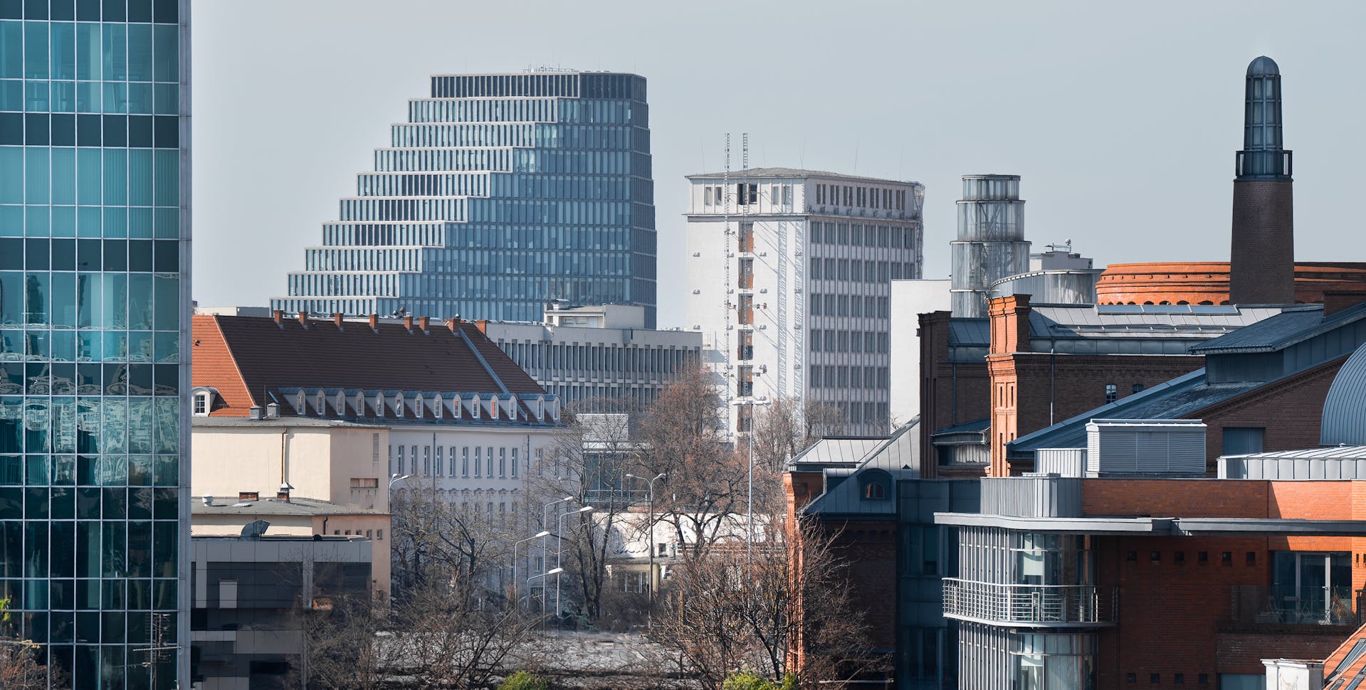 Na zdjęciu widać kilka budynków. Zdjęcie zostało zrobione z góry w formie panoramy. Po prawej stronie widać budynek Starego Browaru, a po lewej kawałek Andersii. Na wprost w większej odległości widać Teatr Muzyczny, Uniwersytet Adama Mickiewicza w Poznaniu oraz biurowiec Bałtyk. Zdjęcie zostało zrobione w pogodny zimowy dzień, na widocznych drzewach nie ma liści. - grafika artykułu