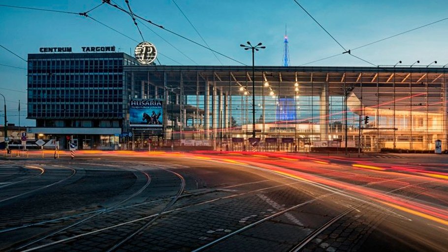 Na zdjęciu wejście główne na Międzynarodowe Targi Poznańskie, na pierwszym planie ślady świateł samochodów