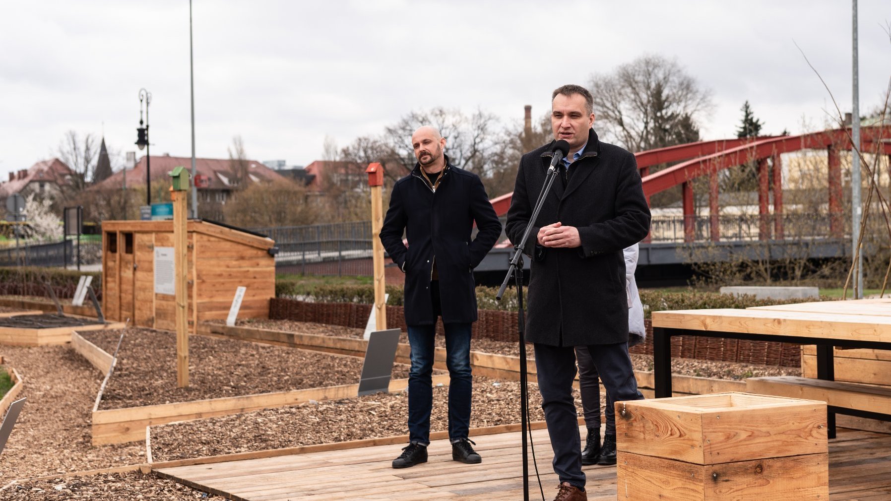 Galeria zdjęć przedstawia ogród eksperymentalny. Widać na nim wydzielone miejsce na rośliny oraz prelegentów konferencji.