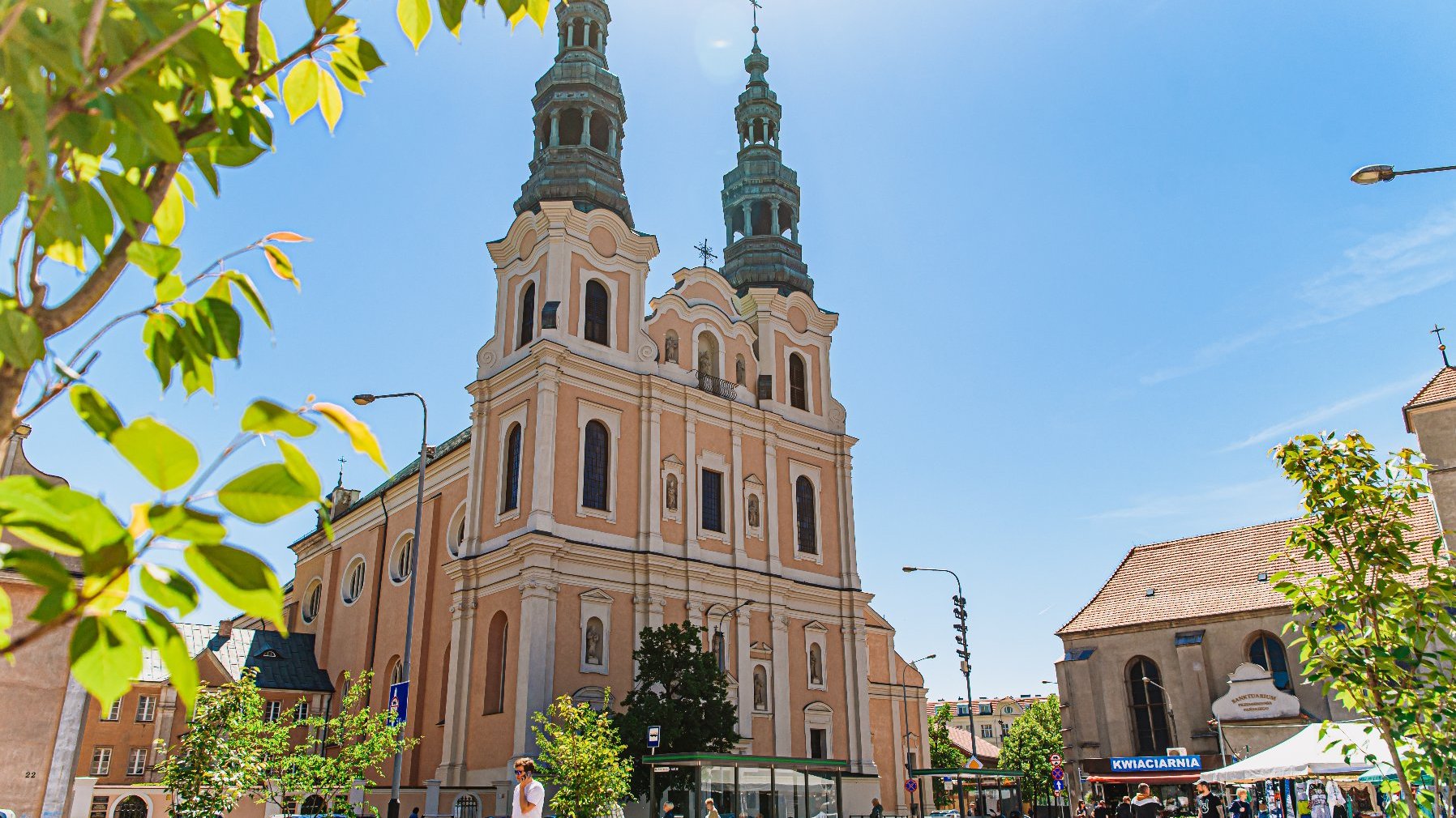 Galeria zdjęć przedstawia plac Bernardyński. Widać na nich donice z roślinami oraz stragany handlowe.