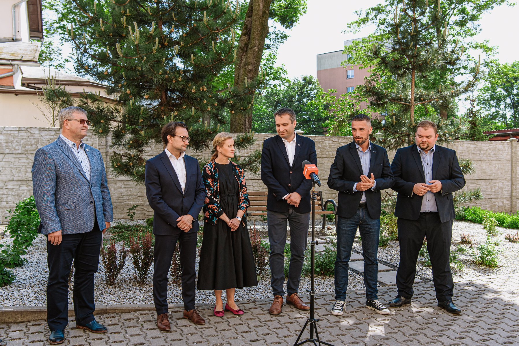 Galeria zdjęć przedstawia zdjęcie podwórka oraz osoby biorące udział w konferencji prasowej. - grafika artykułu