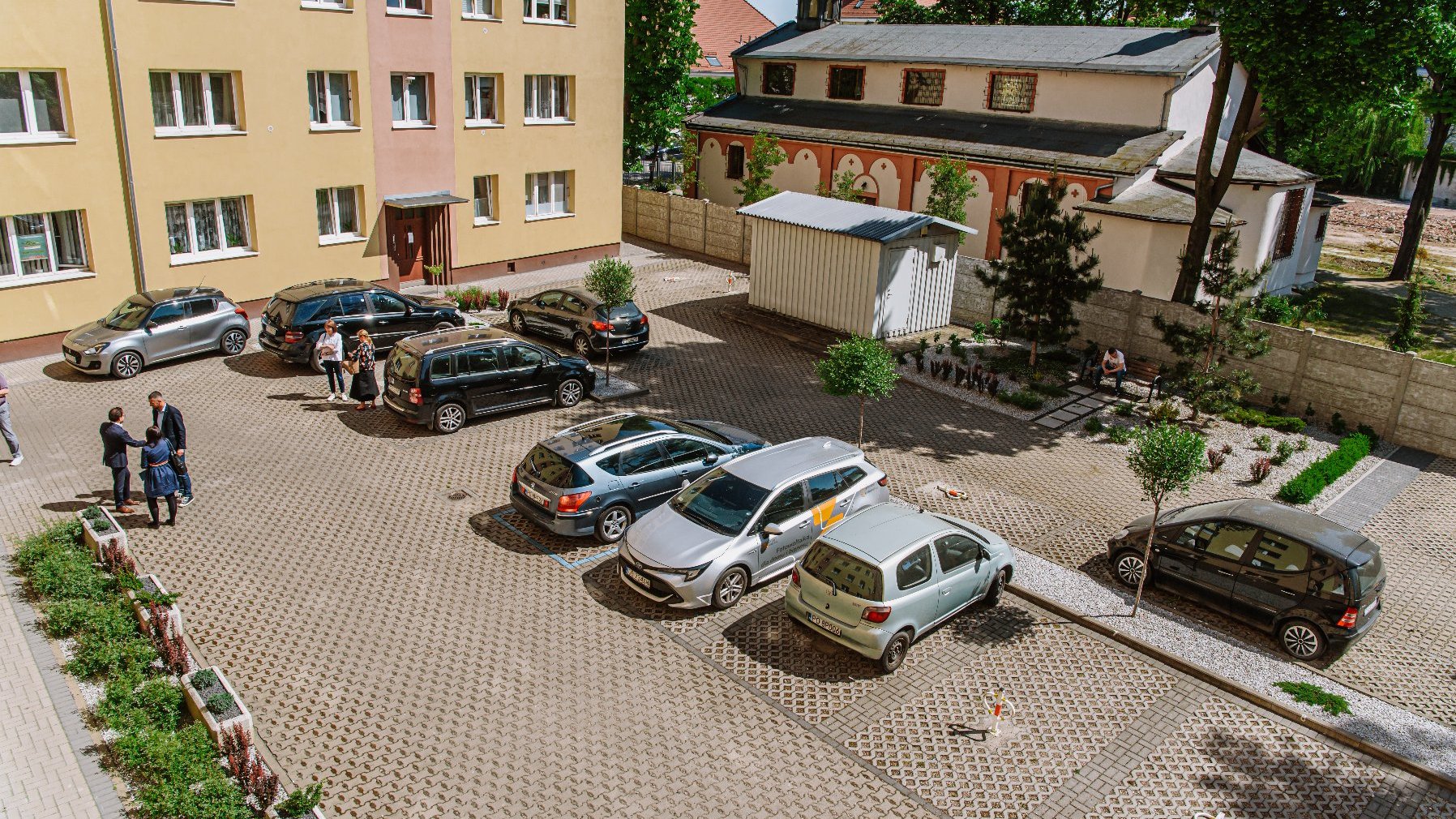 Galeria zdjęć przedstawia zdjęcie podwórka oraz osoby biorące udział w konferencji prasowej.