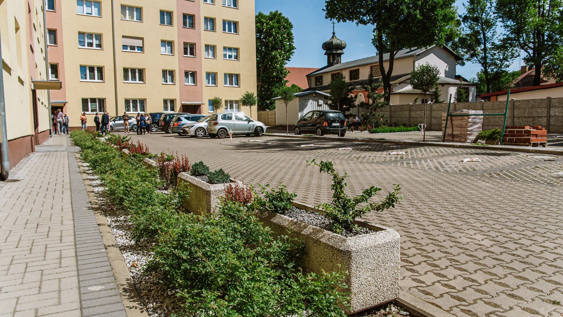 Galeria zdjęć przedstawia zdjęcie podwórka oraz osoby biorące udział w konferencji prasowej.