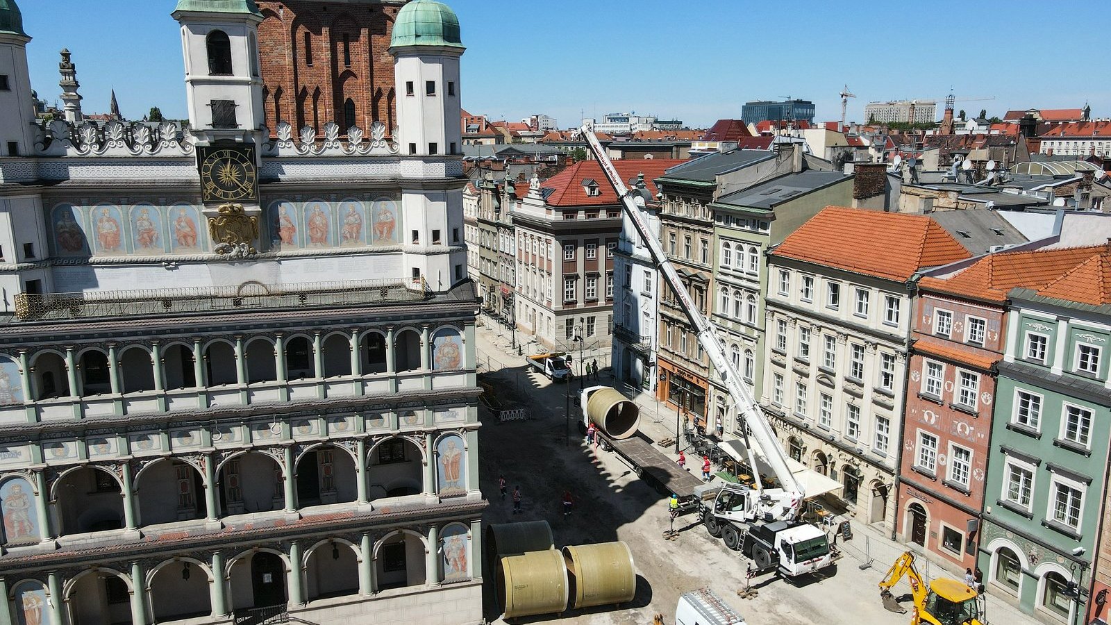 Zdjęcie przedstawia widok na Stary Rynek w Poznaniu z lotu ptaka. Na fotografii widoczen są dachy kamienic i sprzęt budowlany.