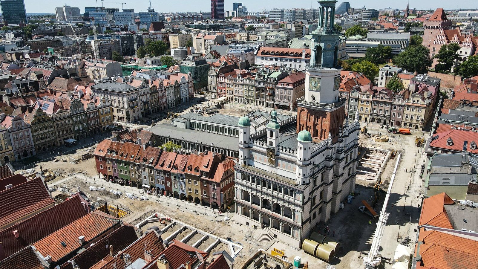 Zdjęcie przedstawia widok na Stary Rynek w Poznaniu z lotu ptaka. Na fotografii widoczen są dachy kamienic i sprzęt budowlany.