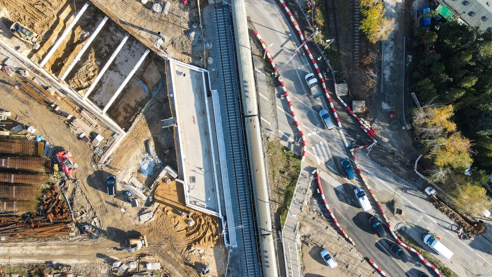 Na zdjęciu węzeł drogowy - plac budowy z lotu ptaka, w centrum biegną tory kolejowe, po prawej widać samochody