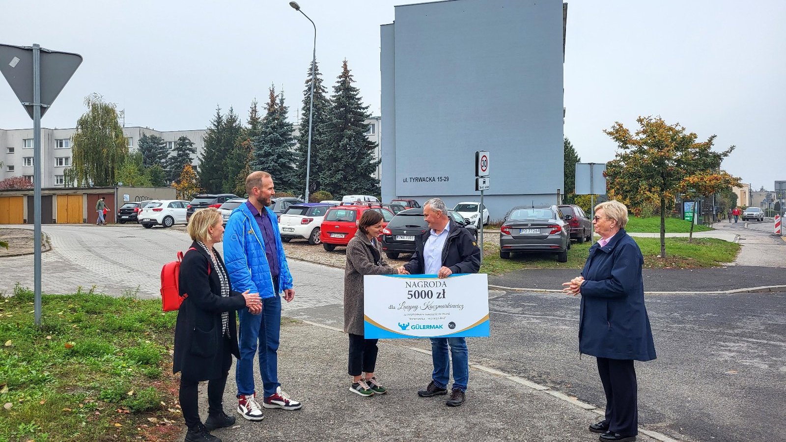 Na zdjęciu autorka muralu odbierająca nagrodę, w tle blok, na którym ma powstać dzieło