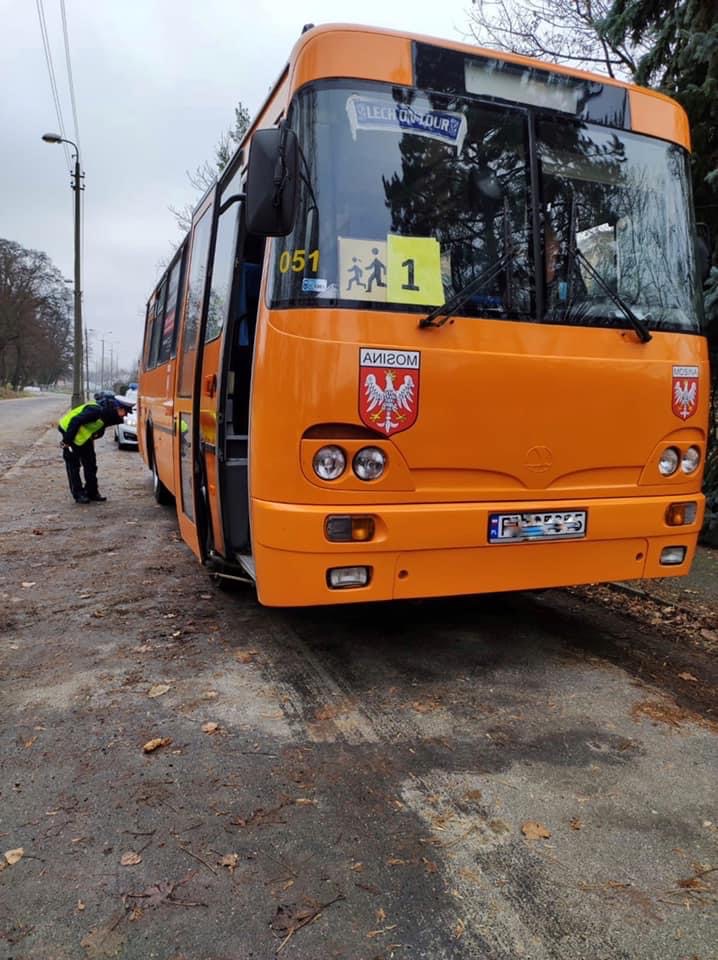 Na zdjęciu policjant przyglądający się tylnej oponie autobusu - grafika artykułu