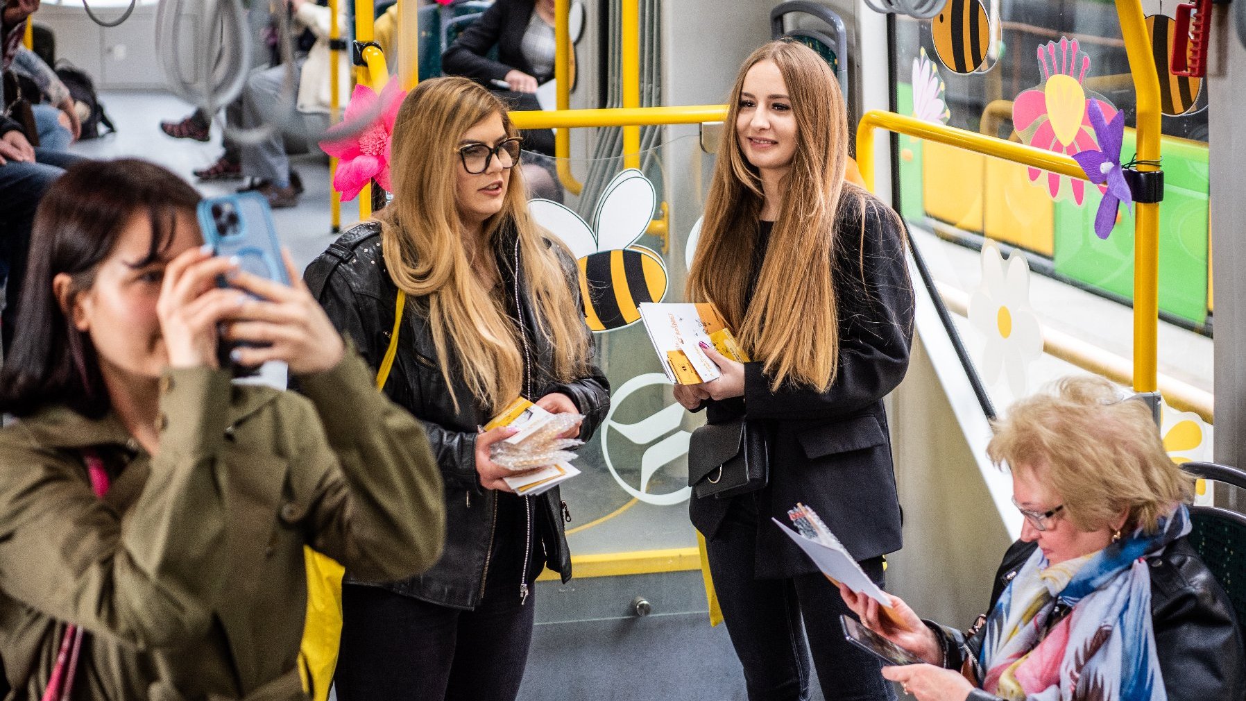 Na zdjęciu wnętrze tramwaju, hostessy rozdające upominki