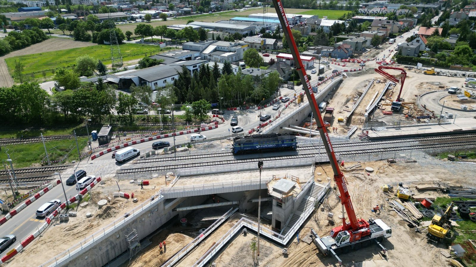 Na zdjęciu wiadukt z lotu ptaka, widać pociąg na torach i dźwig