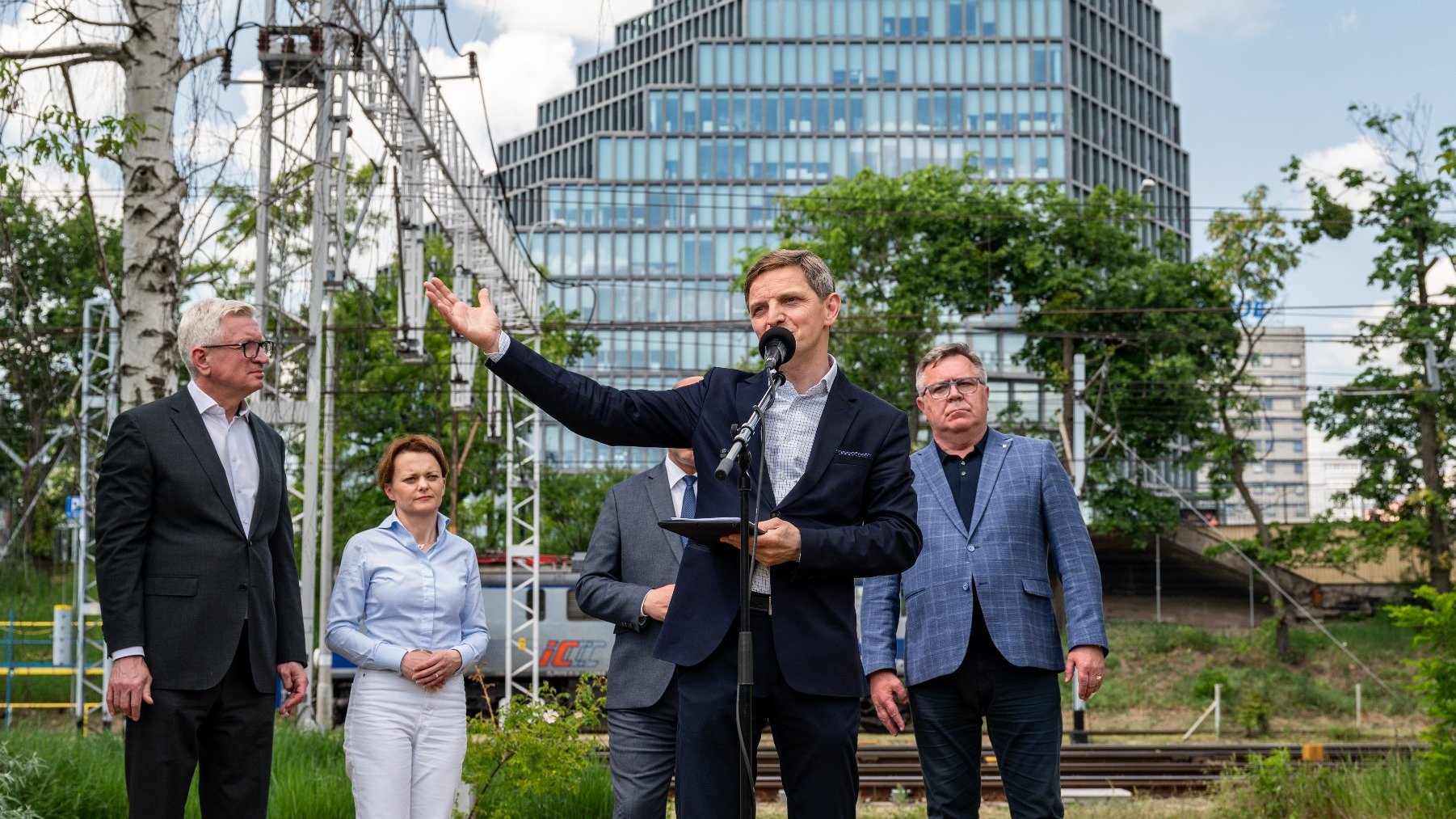 Na pierwszym planie Przemysław Kieliszewski, dyrektor Teatru Muzycznego w Poznaniu. W tle grupa osób i biurowiec "Bałtyk".