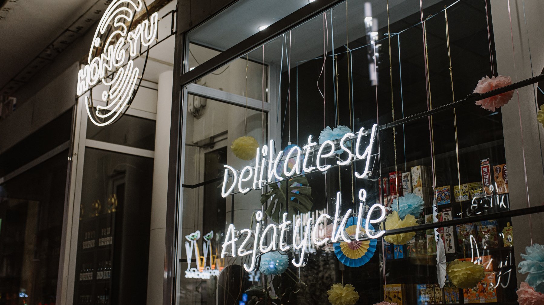 Na zdjęciu biały neon z napisem Delikatesy Azjatyckie