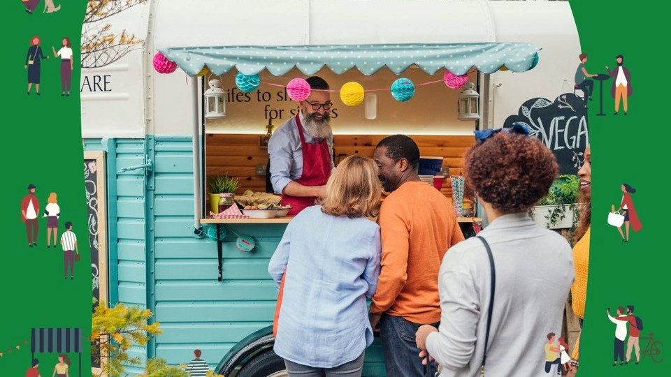 Zdjęcie przedstawia grupę osób stojących w kolejce do foodtrucka. - grafika artykułu