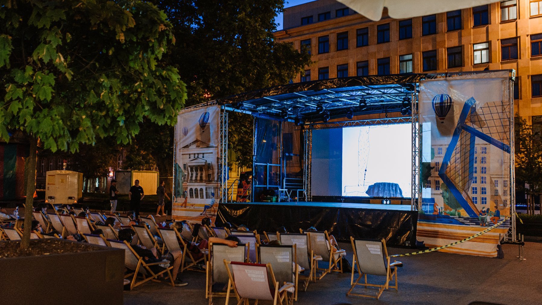 Na zdjęciu ludzie na leżakach na placu wolności oglądają film