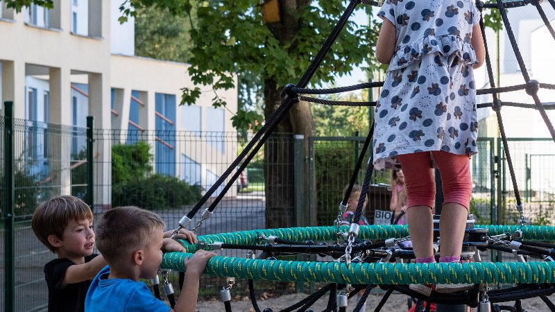 Galeria zdjęć przedstawia plac zabaw dla dzieci. Na zdjęciach widać m.in. zjeżdźalnie czy huśtawki.