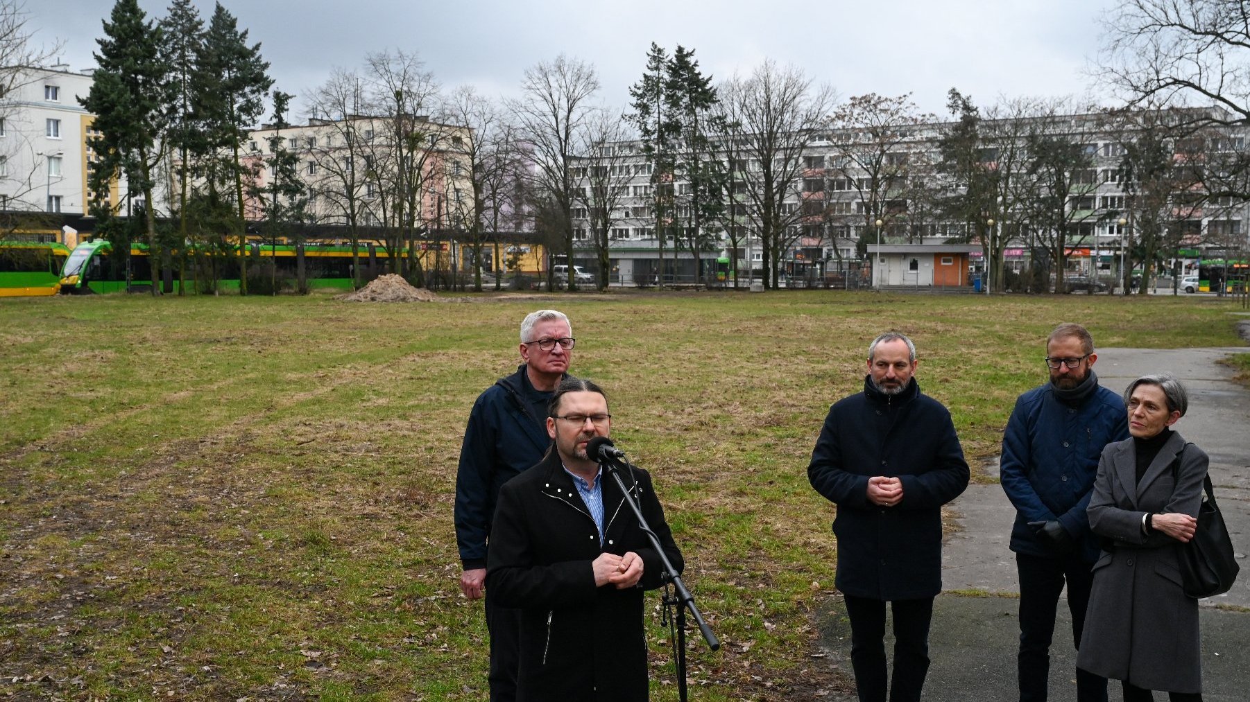 Na zdjęciu pętla ogrody, na niej czterech mężczyzn i kobieta, jeden z mężczyzn mówi coś do mikrofonu