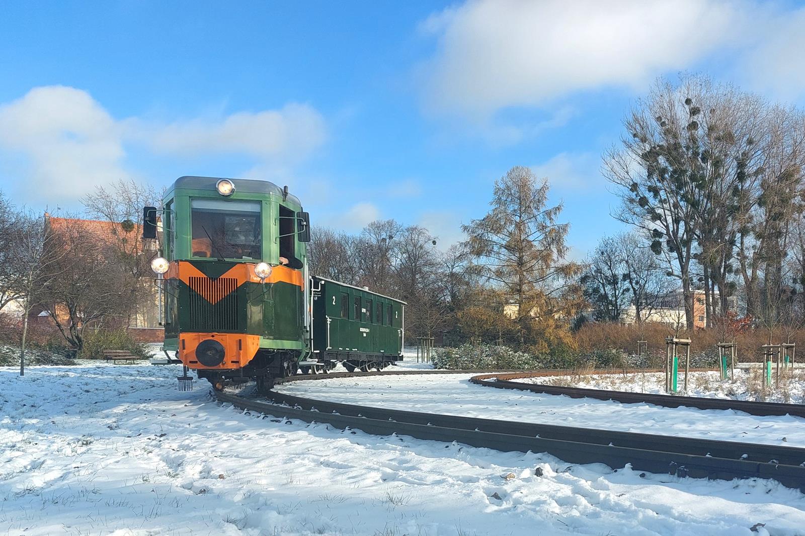 Ryjek ciągnący wagon na łuku torowiska. Dookoła śnieg. - grafika artykułu