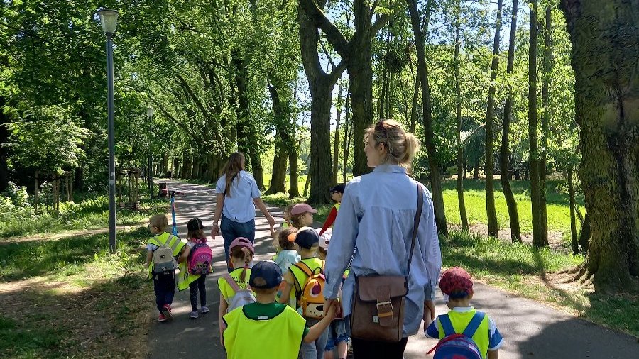 Zdjęcie przedstawia dzieci i opiekunów podczas spaceru.