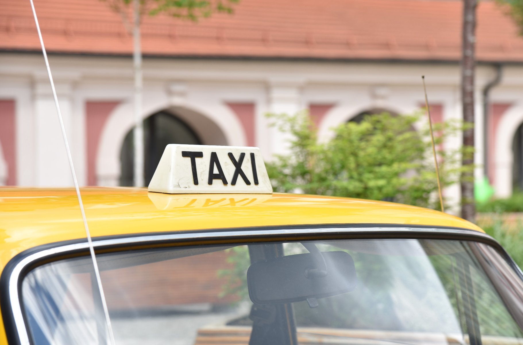 Zdjęcie przedstawia napis taxi na dachu taksówki. - grafika artykułu