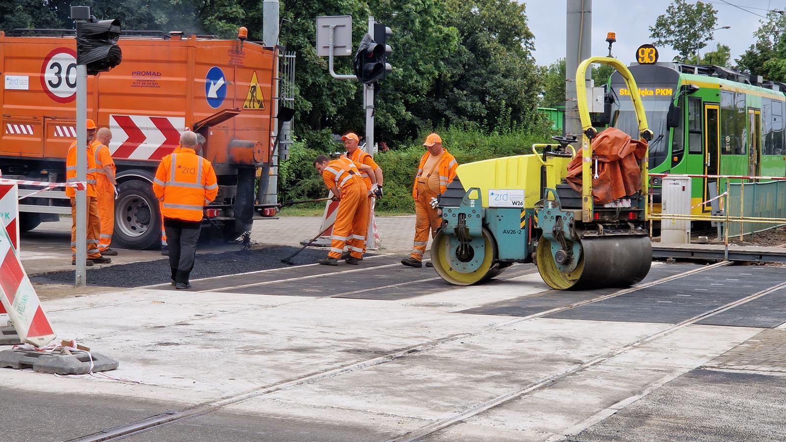 Na zdjęciu na pierwszym planie widoczna nowa nawierzchnia, w tle pracownicy - grafika artykułu