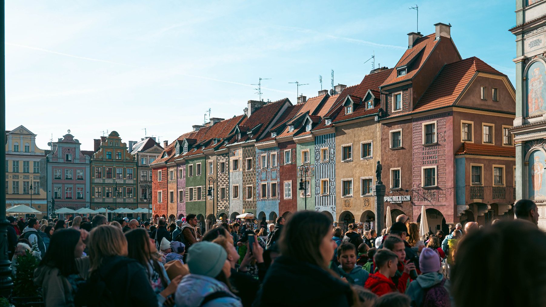 Tłum ludzi na Starym Rynku. W tle widać domki budnicze i kamienicy po południowej stronie