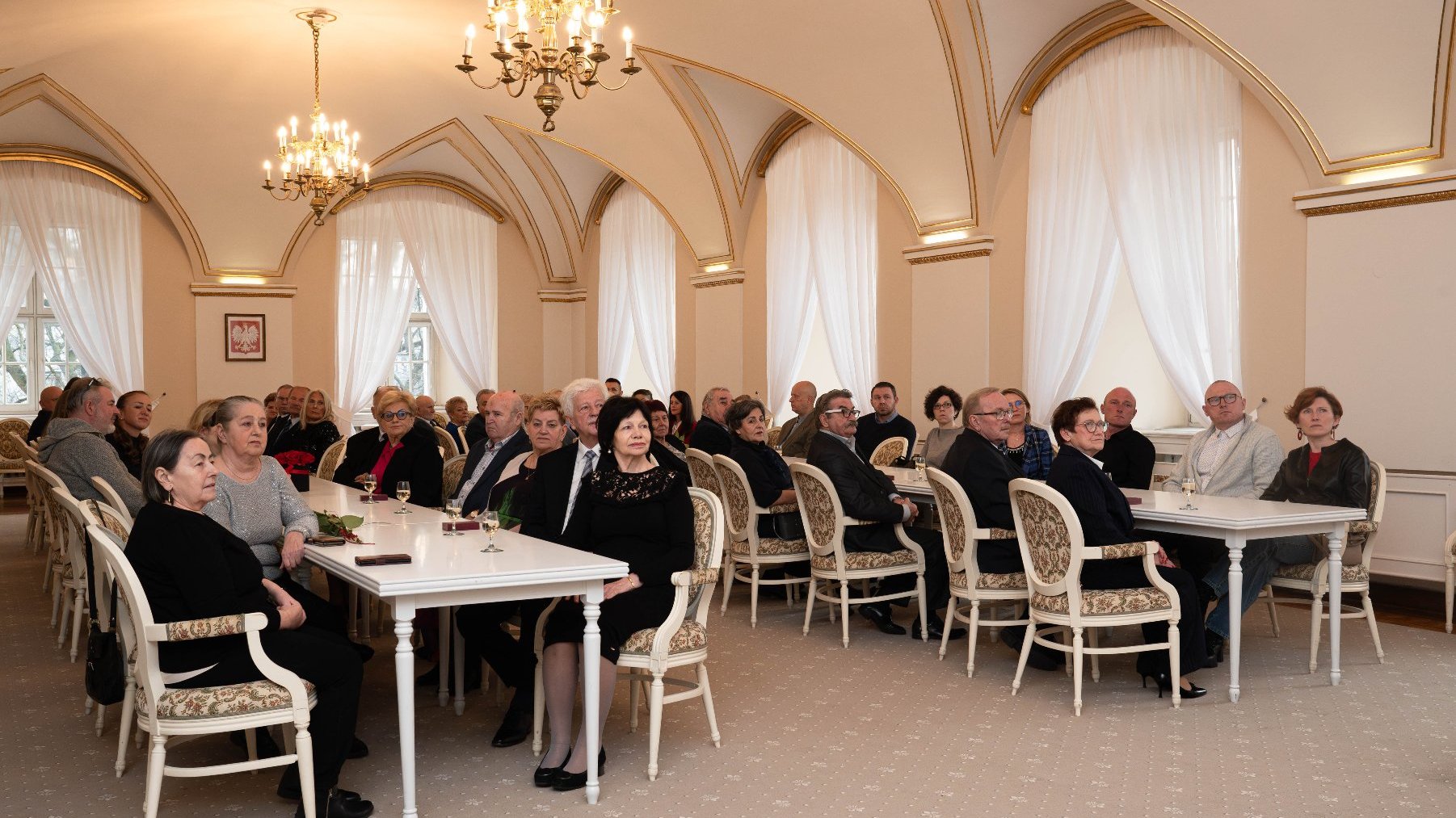 Na zdjęciu grupa ludzi siedzących w Sali Białej Urzedu Miasta Poznania