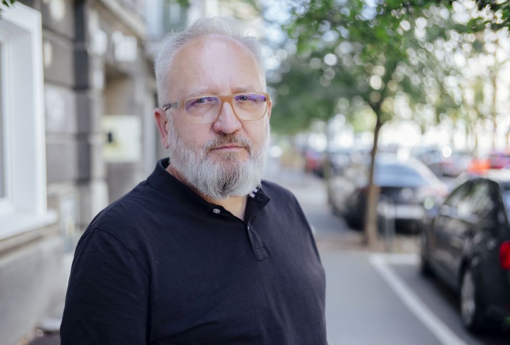 Mariusz Grzebalski , fot. Grzegorz Dembiński Brodaty mężczyzna w okularach stoi na ulicy.