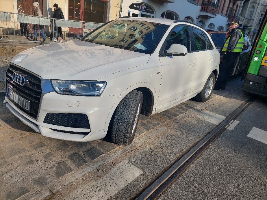 Na zdjęciu działania strażników, polegające na wywozie pojazdu, blokującego przejazd tramwaju - grafika artykułu