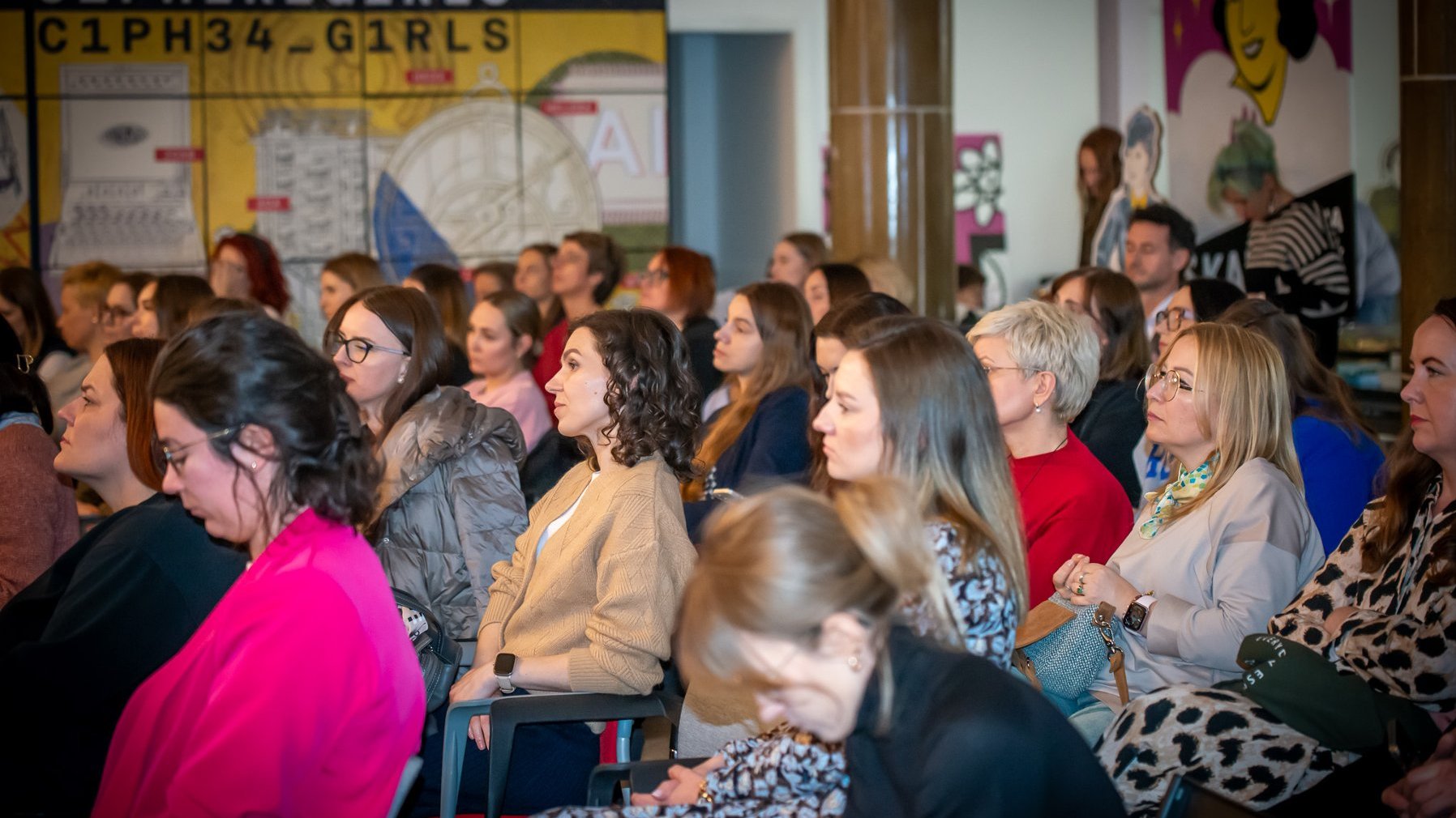 Grafika promująca konferencję.Zdjęcie przedstawiające siedzące kobiety