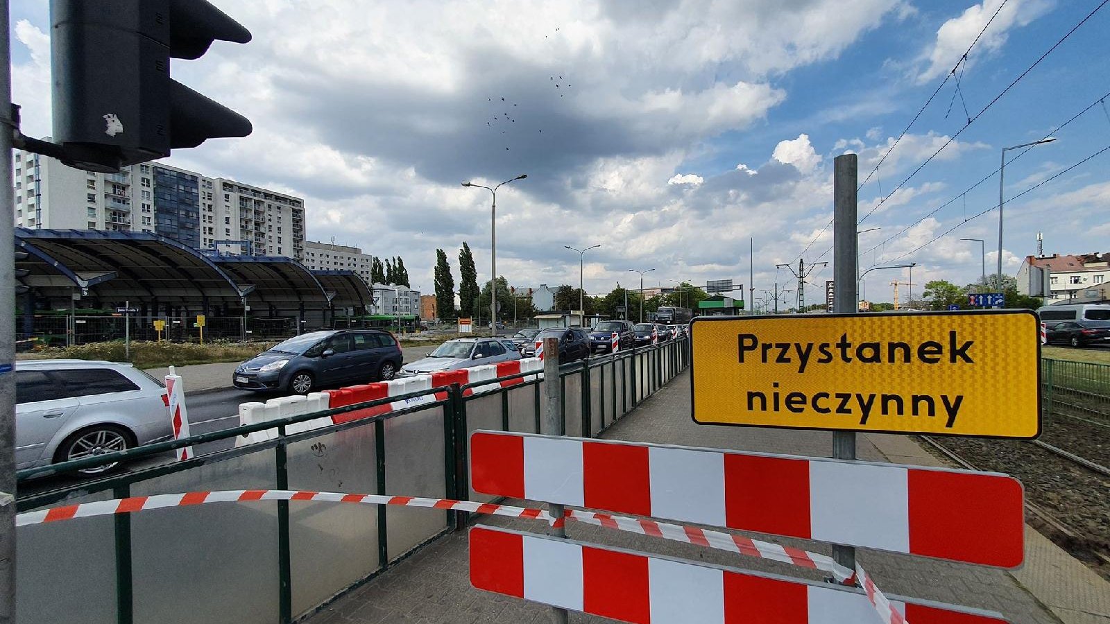 Na zdjęciu znajduje się jezdnia, po której jadą samochody oraz nieczynny przystanek