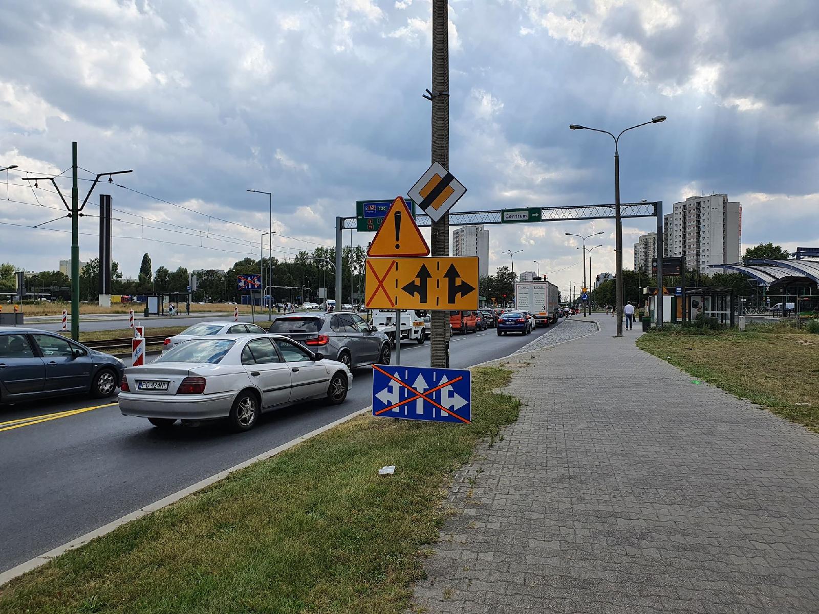 Na zdjęciu znajduje się jezdnia, po której jadą samochody oraz chodnik. W tle widać Dworzec Rataje - grafika artykułu