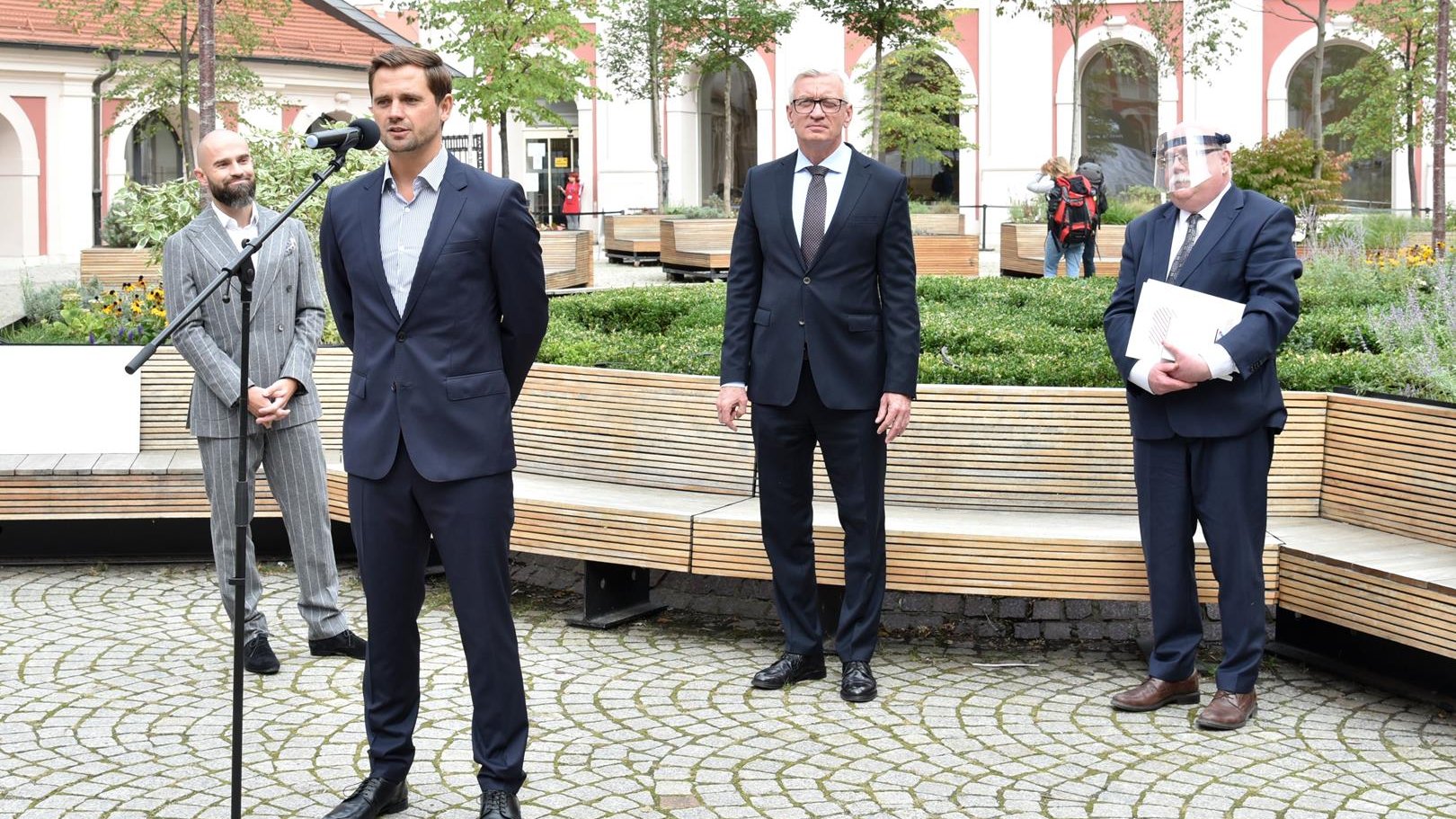 Dziedziniec urzędu. Na pierwszym planie Wojciech Kruczyński, dyrektor zawodów, przy mikrofonie. Za nim: Jacek Jaśkowiak, dr Paweł Daszkiewicz i Sebastian Kulczyk