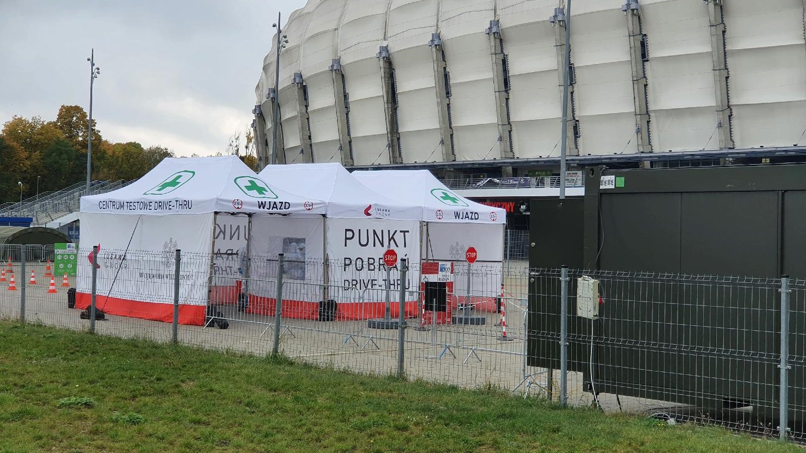 Zdjęcie punktu poboru wymazów. Namiot stoi przy miejskim stadionie.