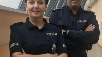 Zdjęcie, dwoje uśmiechniętych policjantów, kobieta i mężczyzna, stoi obok siebie