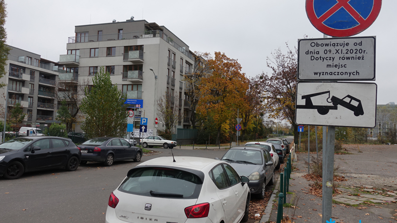 Ulica na Wildzie. Zaparkowane samochody, bloki i znak drogowy z zakazem parkowania od 9.11.2010 r.