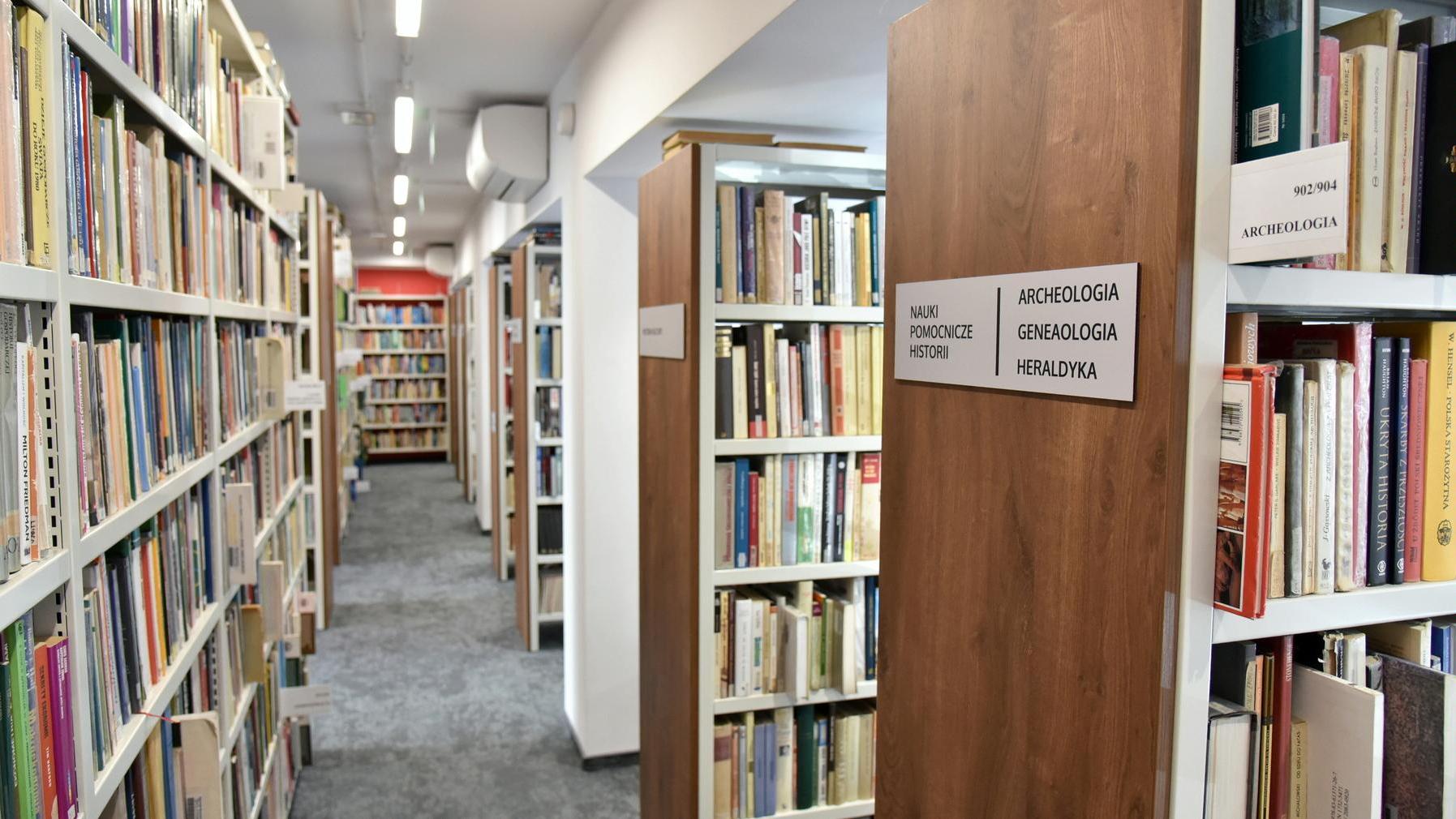 Zdjęcie przedstawia biblioteczne półki z książkami. - grafika artykułu