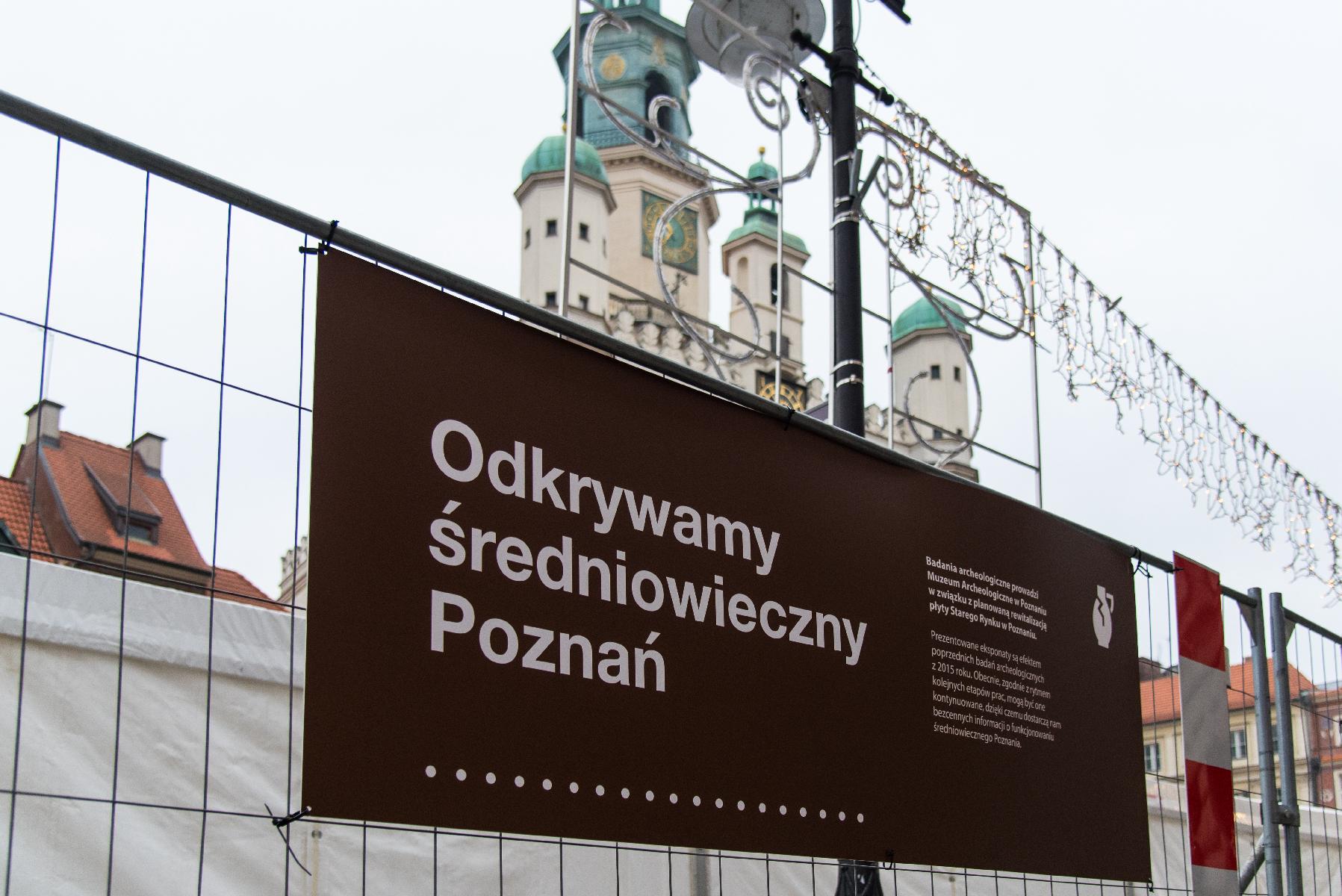 Tablica z napisem "Odkrywamy średniowieczny Poznań". W tle wieża Ratusza. - grafika artykułu