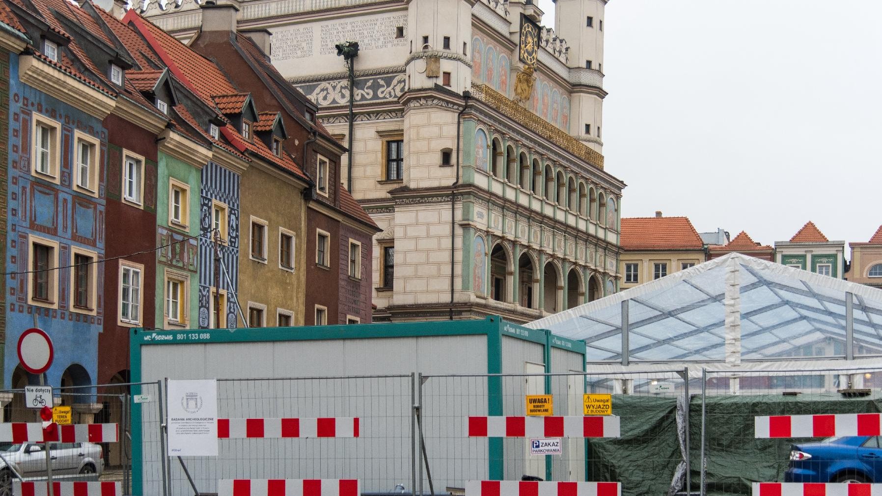 Na pierwszym planie teren prac archologicznych, w tle Ratusz. Po lewej domki budnicze.