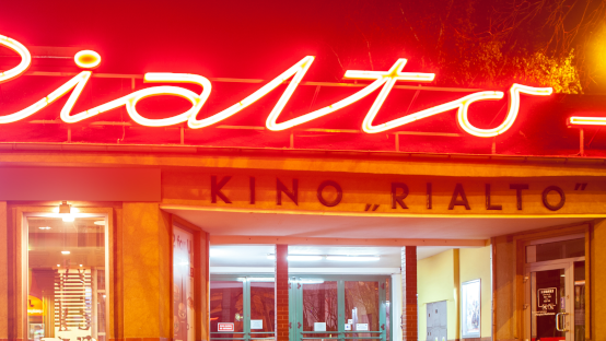 Zdjęcie przedstawia wejście do Kina Rialto. Znajduje się nad nim duży neon z napisem "Rialto".