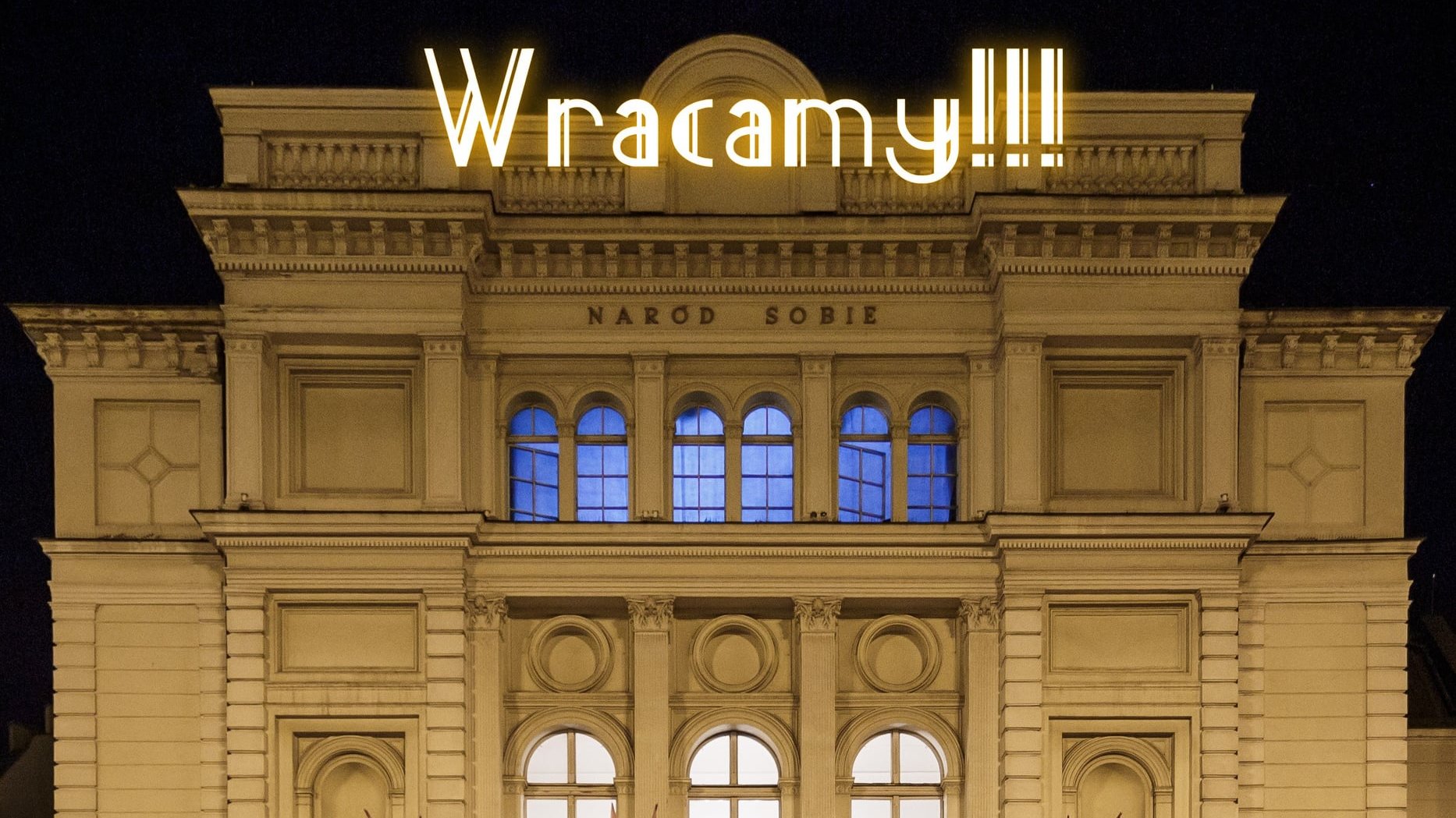 Zdjęcie przedstawia budynek teatru. U góry znajduje się napis "Wracamy!!!", który wygląda jak neon.