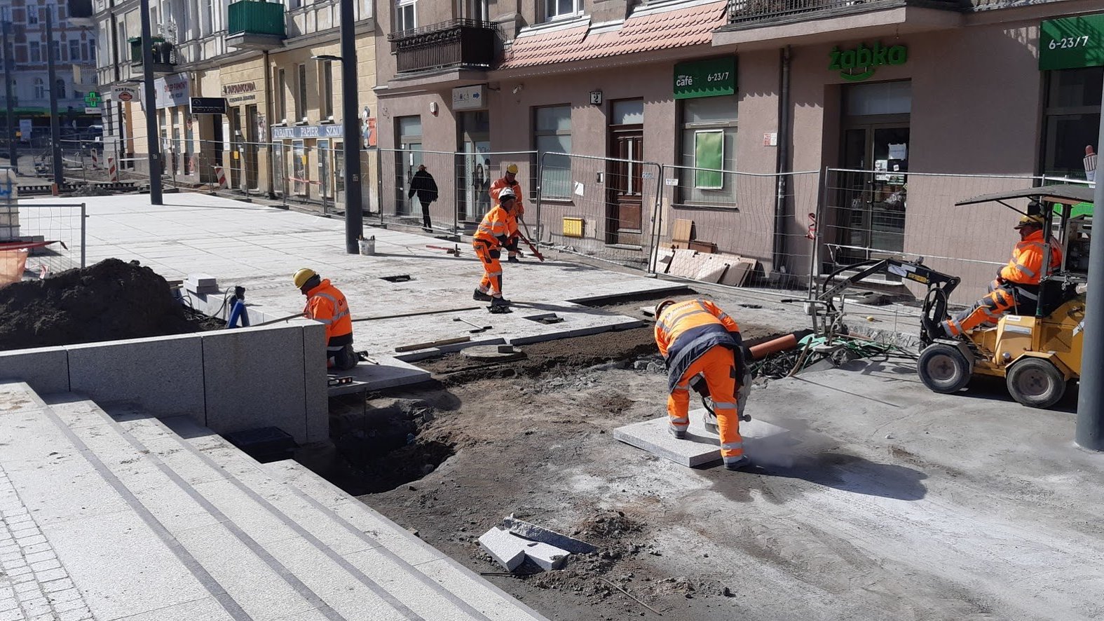 Na zdjęciu Rynek Łazarski - na pierwszym planie schody, w tle - układający chodnik robotnicy