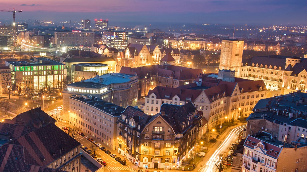 Grafika: panorama Poznania po zachodzie słońca, na pierwszym planie kamienice, w tle CK Zamek - grafika artykułu