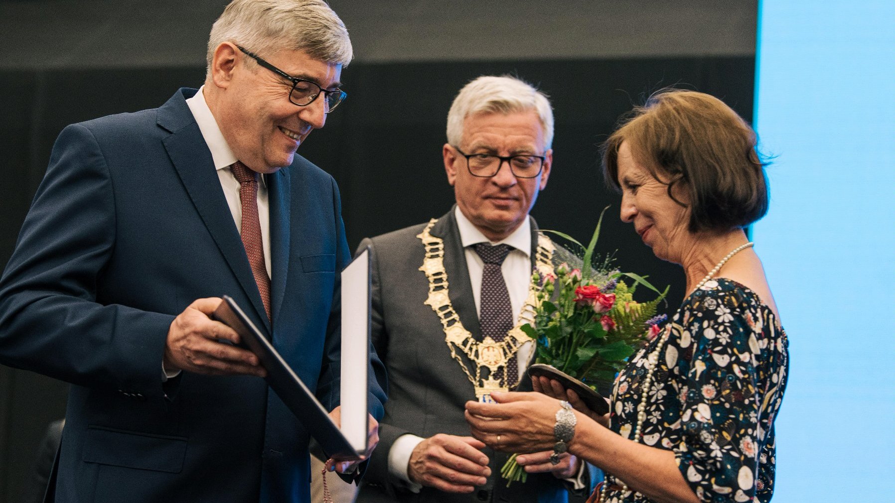 Kobieta - prof. Elżbieta Nowicka - odbierająca nagrodę z rąk Grzegorza Ganowicza, za nią Jacek Jaśkowiak