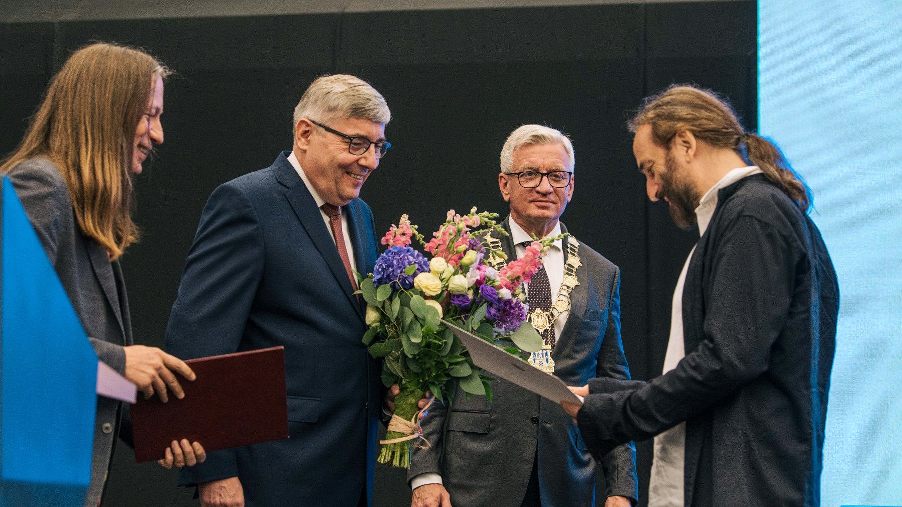 Mężczyzna - Maciej Rychły - odbierający nagrodę z rąk Grzegorza Ganowicza, za nim Jacek Jaśkowiak