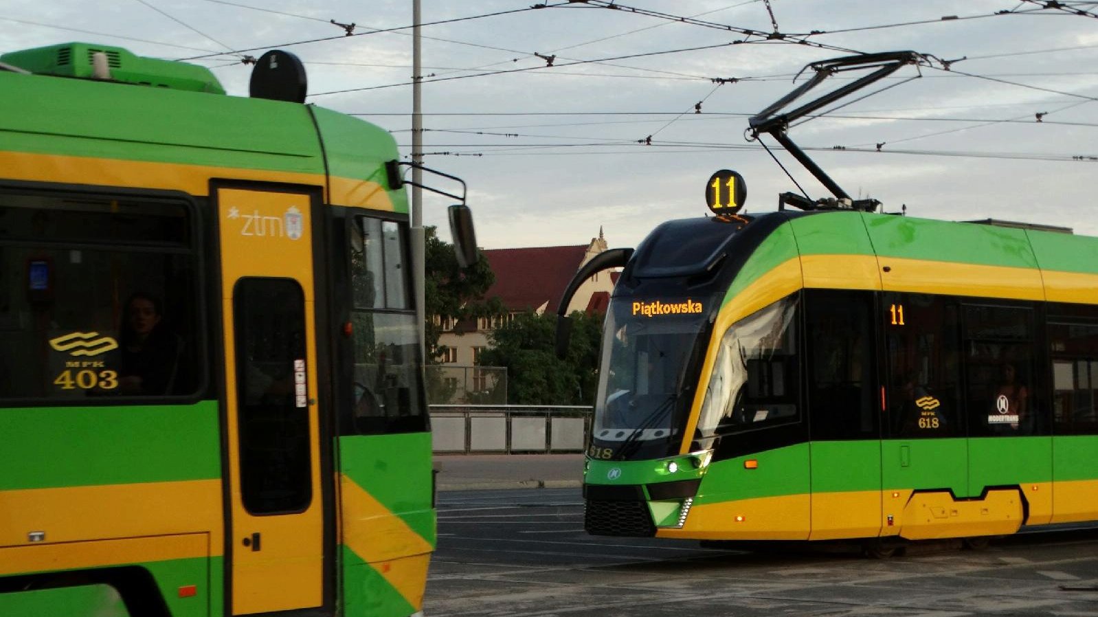 Na zdjęciu dwa tramwaje jadące po torowisku w przeciwne strony, jeden z nich to pojazd linii 11, z napisem "Piątkowska" - grafika artykułu