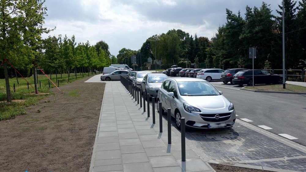 Na pierwszym planie chodnik przy ul. św. Rocha, po lewej drzewa, w centrum zaparkowane samochody