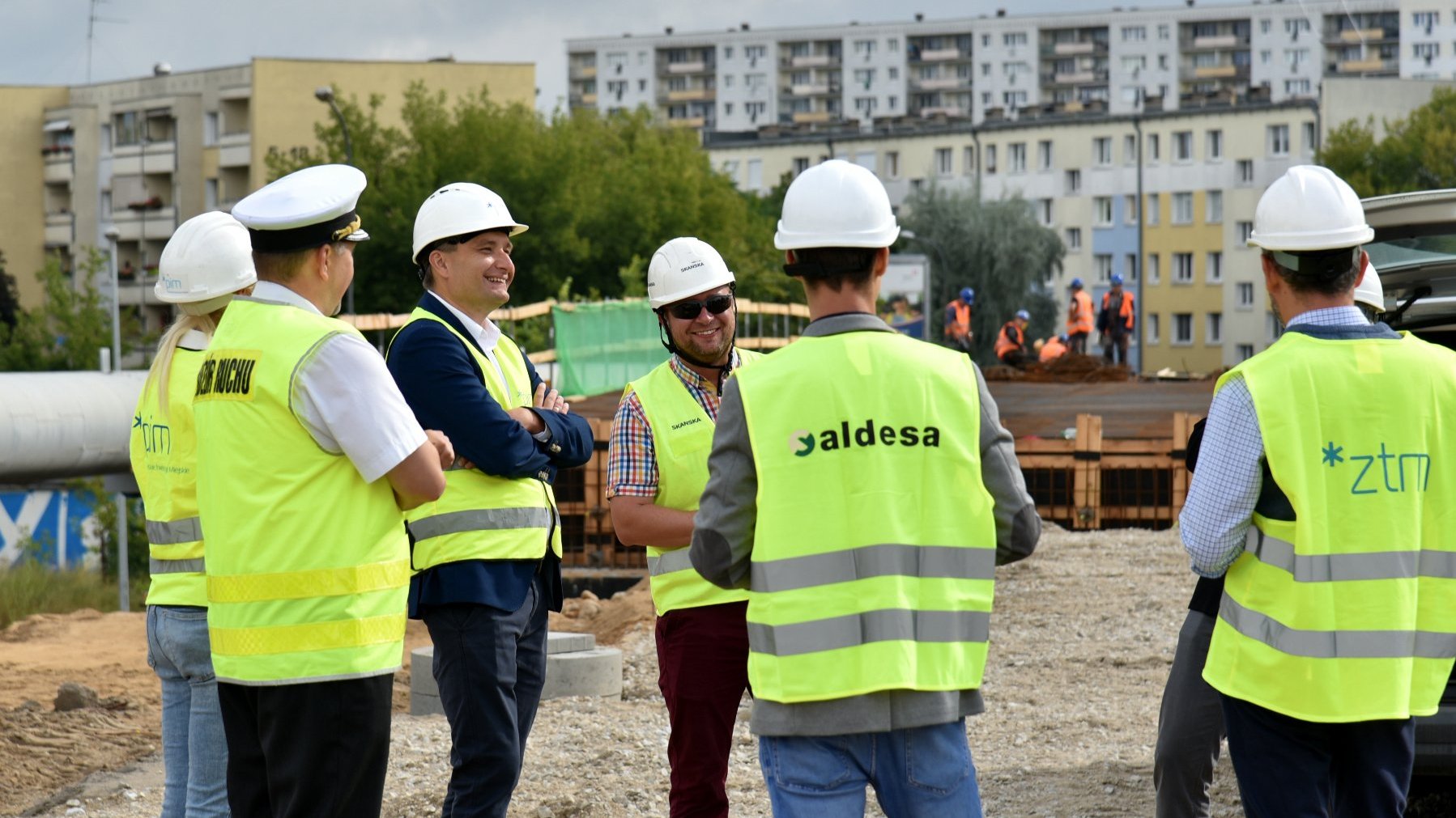 Wiadukt Kurlandzka. Na pierwszym planie grupa osób w kaskach. W tle budynki mieszkalne.